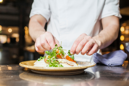 Chef preparing garnish on meal